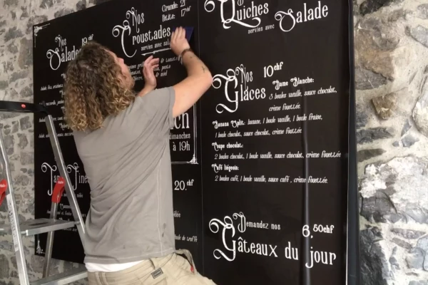 Pose d'un menu ardoise pour un restaurant à Genève, par Stick-Up.ch