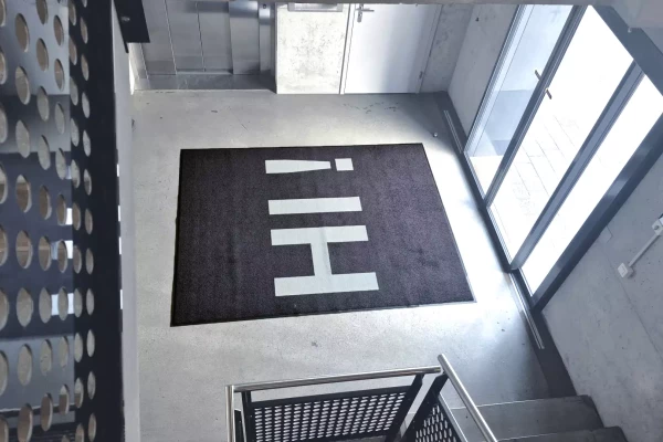 Tapis de sol noir sur mesure avec un texte sur mesure dans un halle d'entrée