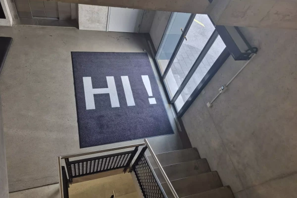 Tapis de sol noir sur mesure avec un texte sur mesure dans un halle d'entrée