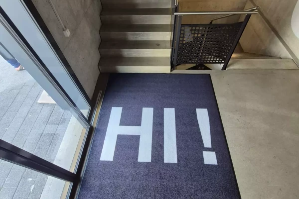 Tapis de sol noir sur mesure avec un texte sur mesure dans un halle d'entrée