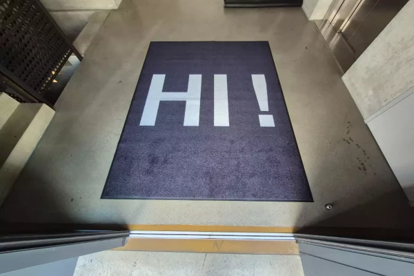 Tapis de sol noir sur mesure avec un texte dans un sasse d'entrée